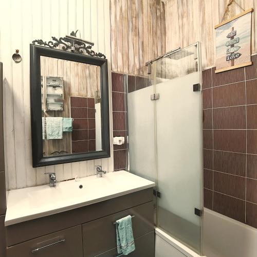 une salle de bain avec un lavabo, un miroir et une douche dans l'établissement Chez Nathou, à La Teste-de-Buch