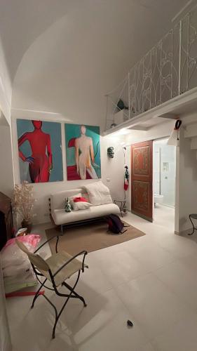 a living room with a couch and paintings on the walls at Casa Stella Marina in Ponza