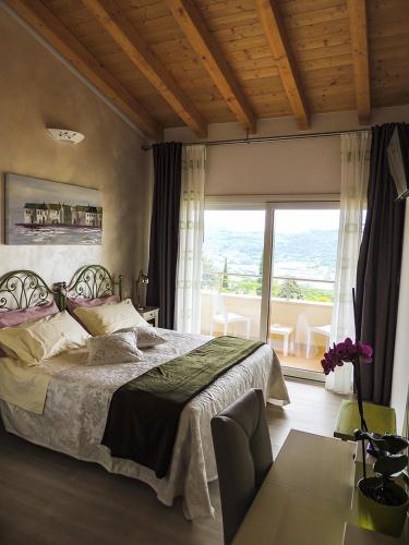 a bedroom with a large bed and a large window at B&B IL RICCIO in Costermano