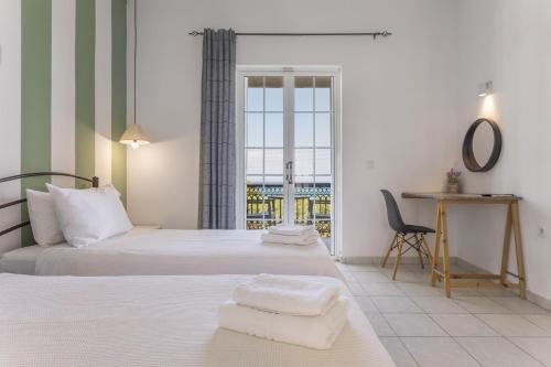 ein Schlafzimmer mit zwei Betten und einem Schreibtisch und einem Fenster in der Unterkunft Bel Momento - Family Room in Alikanas