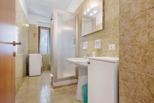 a white bathroom with a sink and a shower at Appartamenti Panelatti in Bono