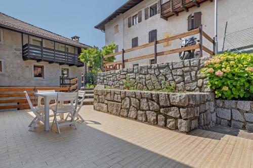 a table and chairs on a patio next to a stone wall at Appartamenti Panelatti in Bono