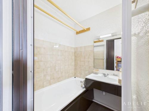 une salle de bain avec une baignoire et un lavabo dans l'établissement Studio rénové, style montagne, pied des pistes, balcon exposé sud, pour 4 personnes à La Rosière - FR-1-398-557, à Montvalezan