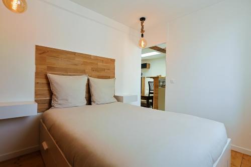 une chambre avec un grand lit avec une tête de lit en bois dans l'établissement Appartement Cosy, à Toulon