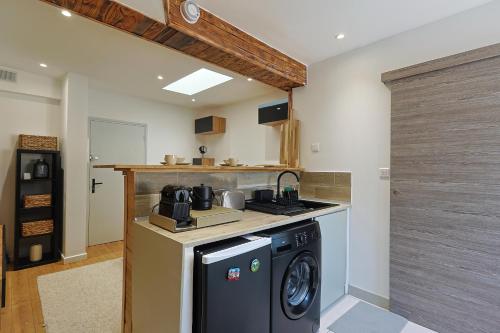 une cuisine avec une cuisinière et une machine à laver dans l'établissement Appartement Cosy, à Toulon