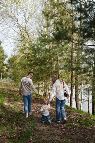 a family walking down a path with a child at Blue&Green Masurian Hotel in Węgorzewo