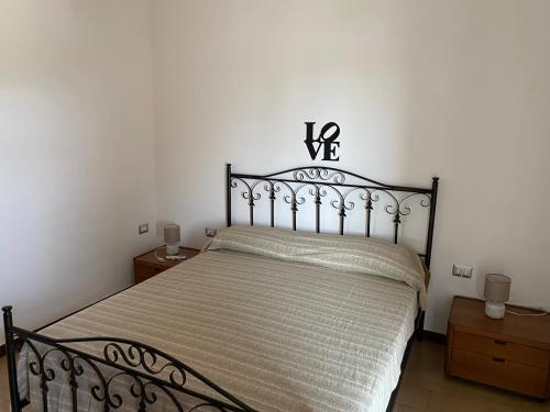 a bedroom with a bed with a black bed frame at Residenza Rogiò in Policoro