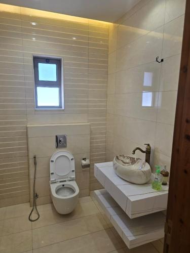 une salle de bain avec toilettes, lavabo et fenêtre dans l'établissement Le Jardin, à Madaba