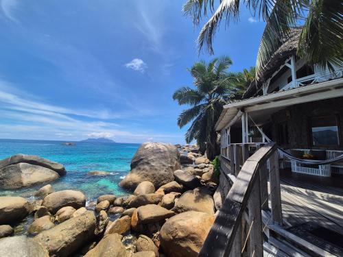 a house on a rocky beach next to the ocean at Marquise & Infinity villas in Glacis