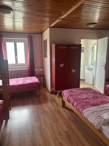 a bedroom with two beds with pink sheets and wood floors at le Belvédère Maison d hotes in Sainte-Anne