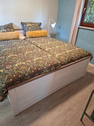 a bed with a floral comforter on top of it at Hochwald chalet in Bad Sachsa