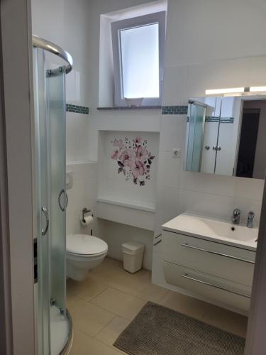 a white bathroom with a toilet and a sink at Mary in Zadar