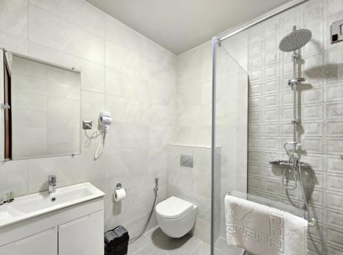 a bathroom with a shower and a toilet and a sink at Tskaltubo Epic Hotel & Spa in Tskaltubo