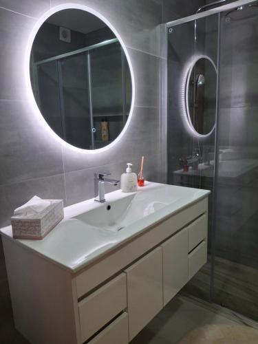 ラゴスにあるPrincess Houseの白い洗面台と鏡のあるバスルーム