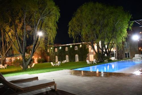 a house with a swimming pool at night at La Posada De Madryn in Puerto Madryn