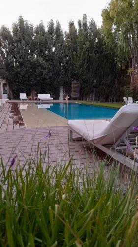 a swimming pool with two lounge chairs next to it at La Posada De Madryn in Puerto Madryn