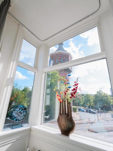 a window with a vase with flowers in it at Stad & Strandhotel Elisabeth in Vlissingen