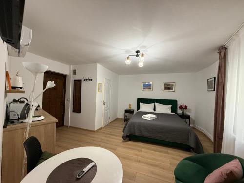 een slaapkamer met een bed en een tafel in een kamer bij Candy-Bombon Sibiu in Sibiu