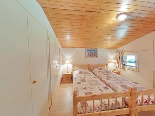 une chambre avec un lit et un plafond en bois dans l'établissement Appartement ensoleillé 3 pièces - 6 pers avec cheminée au Grand Bornand, proche des pistes - FR-1-241-117, au Grand-Bornand
