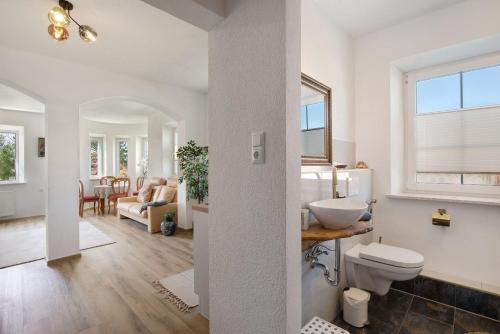 a bathroom with a toilet and a living room at Villa Romantika in Ichenhausen