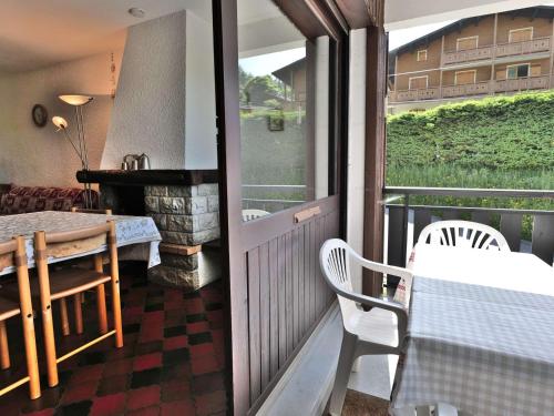 d'un balcon avec une table, des chaises et une cheminée. dans l'établissement 3 pièces duplex au pied des pistes! - FR-1-458-104, au Grand-Bornand