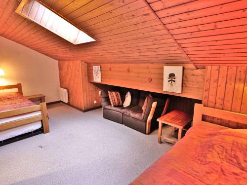 une chambre avec un lit et un canapé dans une pièce dans l'établissement 3 pièces duplex au pied des pistes! - FR-1-458-104, au Grand-Bornand