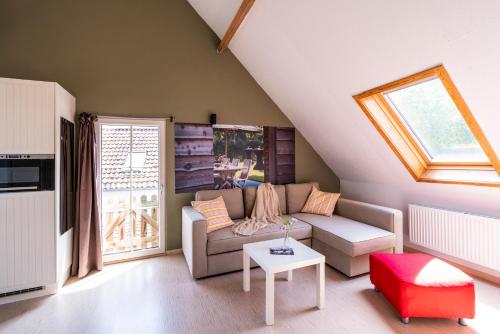 a living room with a couch and a table at Lozer Lodge Vakantiewoning in Kruisem