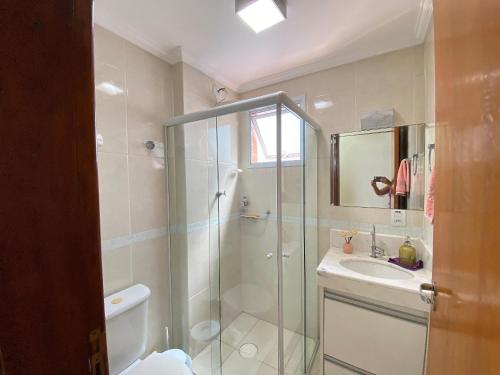 ein Badezimmer mit Dusche und Waschbecken in der Unterkunft Conforto na Praia – Apto 2 Qtos Guilhermina in Praia Grande