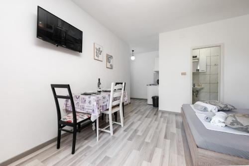 a living room with a dining table and a bed at Apartman Biljana in Makarska