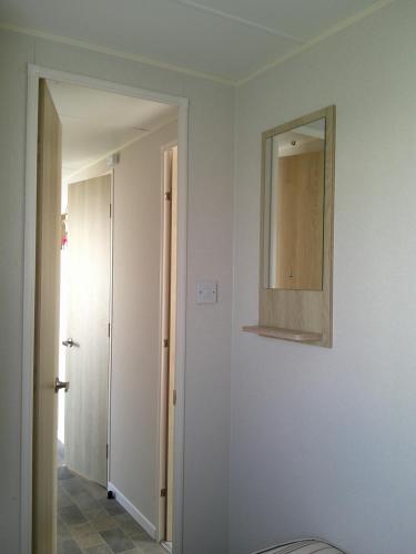 a white room with a mirror on the wall at Kingfisher New Horizon Firs 8 Berth Blow Heated in Ingoldmells