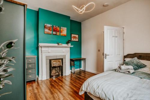 a bedroom with green walls and a bed with a fireplace at Open Mind Property - 4 Bedroom House with Hot Tub in Weston-super-Mare