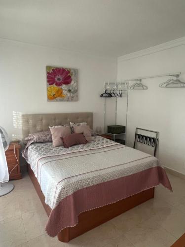 a bedroom with a large bed with pink pillows at Estudio MAR EN CALMA, Primera Línea de Playa con Vistas al Mar in Torrox