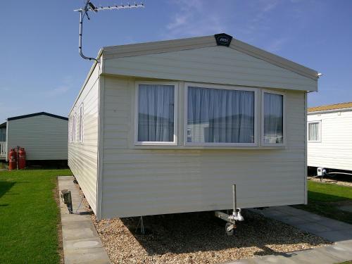 a tiny house is parked in a yard at Kingfisher New Horizon Firs 8 Berth Blow Heated in Ingoldmells