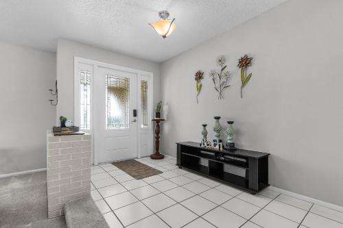 Habitación blanca con puerta y suelo de baldosa. en Charming Retreat with Paddleboards for Adventure - Much Ado About Sunshine - Roelens, en Cabo Coral