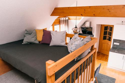 a bedroom with a wooden bed with pillows at Ferienwohnung Alte Schneiderei in Heideck
