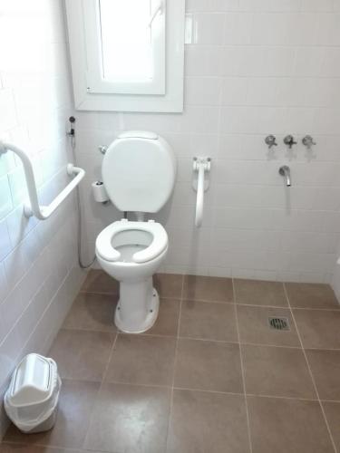 a bathroom with a white toilet and a window at La Posada De Madryn in Puerto Madryn