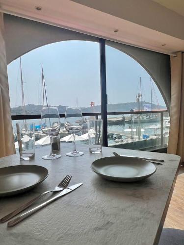 - une table avec des assiettes et des verres et une vue sur le port dans l'établissement 1st line sea view apartment, à Villefranche-sur-Mer