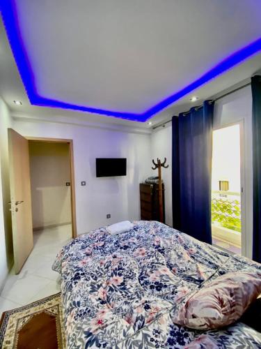 um quarto com uma cama com teto azul em Hay el mohamadi agadir em Agadir