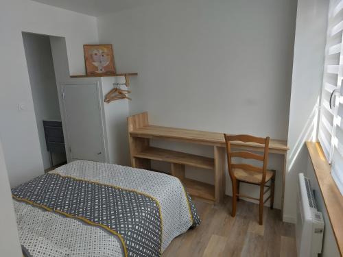 - une chambre avec un bureau, un lit et une chaise dans l'établissement Appartement Rdc, Morgat Plage, à Crozon