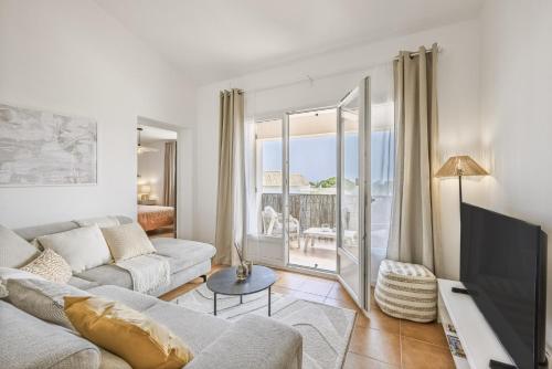 un salon avec un canapé et une télévision dans l'établissement SOLEIA - Vue Mer, Piscine & Jardin privé, Parking, à Roquebrune-sur Argens