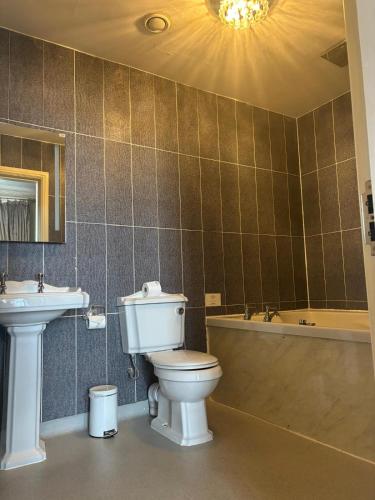 a bathroom with a toilet and a sink and a tub at White Star Line Hotel in Liverpool