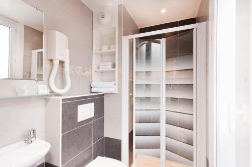 a bathroom with a toilet and a sink at Hôtel Montsouris Orléans in Paris