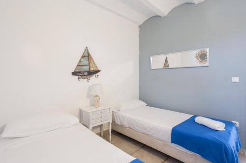 1 dormitorio con 2 camas y un velero en la pared en Oliwood Beach - Tango, en Playa