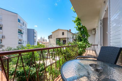 a balcony with a table and chairs on a building at Apartman Biljana in Makarska
