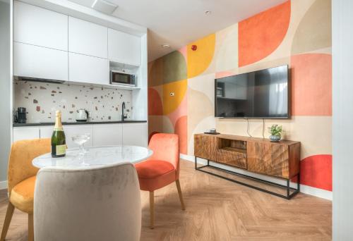a living room with a table and a television at Retro Boutique by NorthSide Apartments in Gdańsk