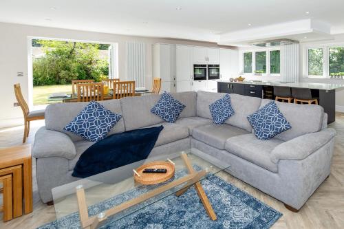 a living room with a gray couch with blue pillows at NEW! Stunning & Huge 5BR with Parking & Garden - Perfect for Families & Groups! Excellent Location in Saint Leonards