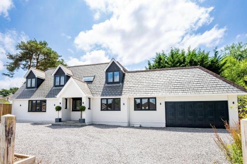 a white house with a garage at NEW! Stunning & Huge 5BR with Parking & Garden - Perfect for Families & Groups! Excellent Location in Saint Leonards