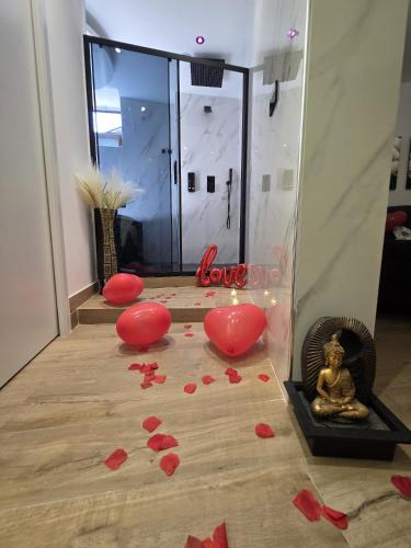 a room with red hearts on the floor and a statue at Elite Apartment SPA in Catania