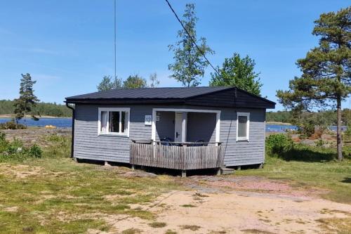a small grey house with a black roof at Eckerö Camping & Stugor in Eckerö