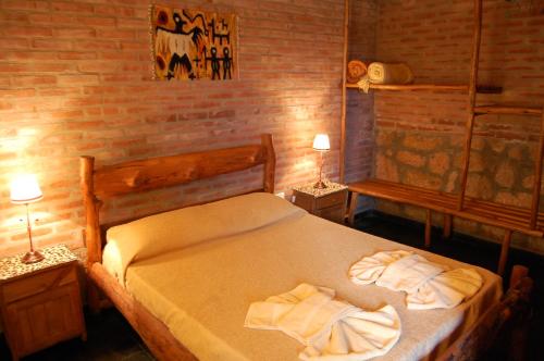 1 dormitorio con 1 cama con toallas en Alto Valle Cabañas de Montaña en Mina Clavero